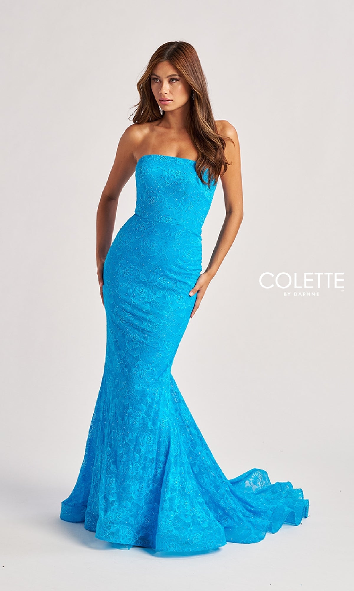 A woman wears the Long Prom Dress: Colette CL8670—a strapless, form-fitting mermaid gown in bright blue lace with a slight train—standing against a neutral background.